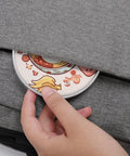 Person placing an Ultra Slim Qi Wireless Charger With Aluminum Alloy Frame 6mm Thin 10W Fast Charging Pad into a bag