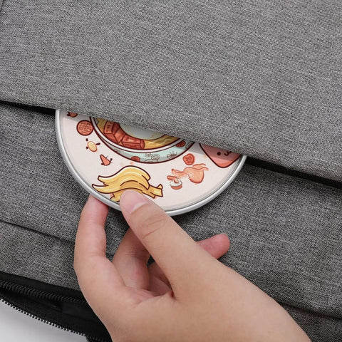 Person placing an Ultra Slim Qi Wireless Charger With Aluminum Alloy Frame 6mm Thin 10W Fast Charging Pad into a bag