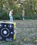 Travel Pro Portable Layered Foam Archery Target in field with children holding bows, 18x16x11 inches for up to 280 FPS use.