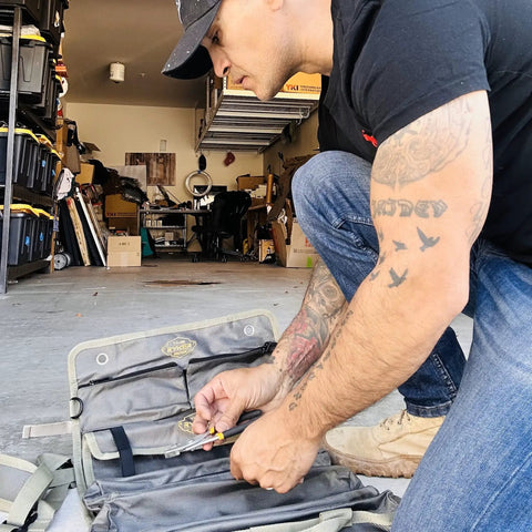 Pro Tool Bag Organizer Foldable Roll Up With Detachable Pouches in a garage, used by mechanic for organizing tools.