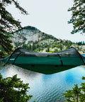 Forest Green Hybrid Ground Tent Or Hammock With Strap Bundle For Car Camping And Backpacking suspended between trees