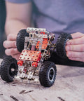 Person assembling car from Beast Mode Erector Set Metal Model Kit For Adults Teens And Advanced Kids Build Cars Planes And Excavators