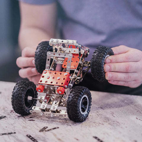 Person assembling car from Beast Mode Erector Set Metal Model Kit For Adults Teens And Advanced Kids Build Cars Planes And Excavators