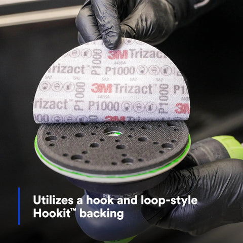 Gloved hand holding Trizact Hookit 3 Inch P1000 Grit Blending Disc Gray, showing hook and loop system for auto body sanding.