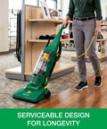 Heavy Duty Bagless Upright Vacuum Chomping Debris On Carpets Hardwood Floors And Furniture With Beastly Suction Plus Onboard Tools And Commercial Filtering For Daily Grind Cleaning in action on hardwood floor.