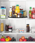 Huge 16 Inch Lazy Susan Turntable With Soft Non Slip Lip And Deep Ledge in a fridge with various bottles and jars.