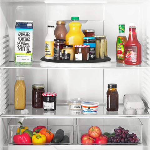 Huge 16 Inch Lazy Susan Turntable With Soft Non Slip Lip And Deep Ledge in a fridge with various bottles and jars.