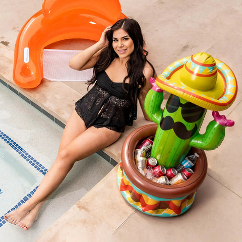 Forty Three Inch Inflatable Cactus Cooler With Sombrero Hat For Fiesta And Cinco De Mayo Party Supplies next to a poolside woman