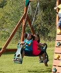 Two children on Dual Ride Glider Back-To-Back Tandem Swing For Kids with green plastic coated chains outdoors