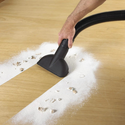 Person using vacuum with High Efficiency Disposable Filter Bags For 15-22 Gallon Tanks White 2-Pack collecting drywall dust