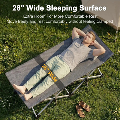 Man relaxing on Beefy 28 Inch Wide Camping Cot For Adults, Heavy Duty 1200D Oxford Fabric, Portable Folding Camp Bed in grassy area.