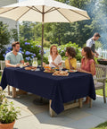 Outdoor Table Cover With Umbrella Hole And Zipper 60x84 Inch Navy Low Maintenance Washable Waterproof Spill Proof Wrinkle Free Tablecloth For Patio Porch Spring Summer Bbqs Picnics shown on patio table with people dining