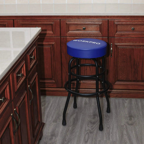 Heavy-Duty Steel Garage Shop Stool With Swivel Cushion Seat, Four Sturdy Legs, 360 Degree Foot Rings, Black Powder Coated Frame And Footrest, Single Pack positioned against brown cabinets in a kitchen setting.