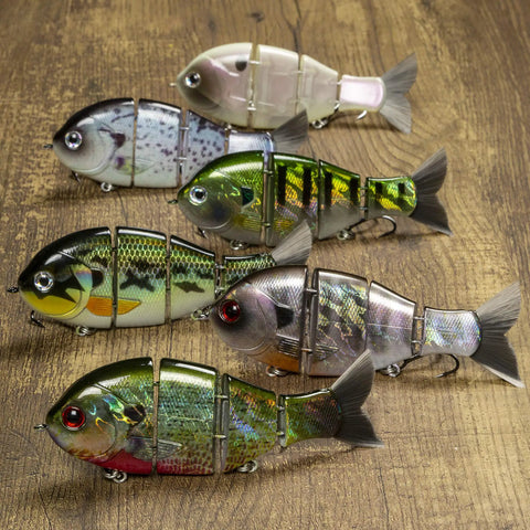 Mike Bucca Baby Bull Gill Swimbait, 3.75 Inch, Three Quarters Ounce Ruby Gill, shown in multiple finishes on wooden surface