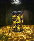 Outdoor Solar Lanterns For Garden Decor, Hanging Metal Sun Moon Star Lights glowing in a garden setting at night