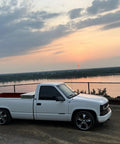 White Chevy Silverado 1500 1988 To 1998 Lowering Kit With 5 Inch Front Drop Spindles parked by a lake at sunset