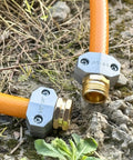Close-up of Four Pack Hose Repair Kit For Garden And Water Hoses, Heavy Duty Aluminum Fittings With Zinc Alloy Clamps on a garden hose.