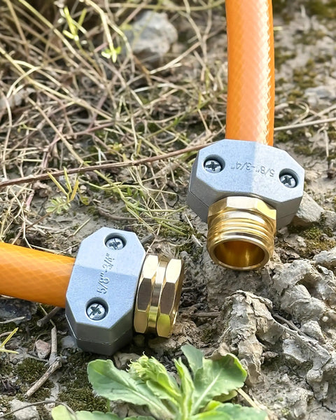 Close-up of Four Pack Hose Repair Kit For Garden And Water Hoses, Heavy Duty Aluminum Fittings With Zinc Alloy Clamps on a garden hose.