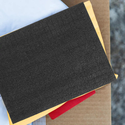 Black Foam Storage Box With Sponge Padding for Electronics and Household Items atop other packaging materials