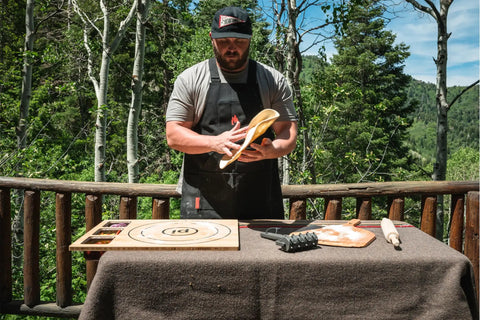 Man using a large bamboo cutting board with 3 shatter resistant containers and lids for kitchen prep outdoors, anti slip rubber feet.