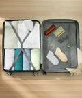 Top-down view of open Amazon Basics 30-inch black hardside spinner luggage, with clothes on left and mesh pocket on right.