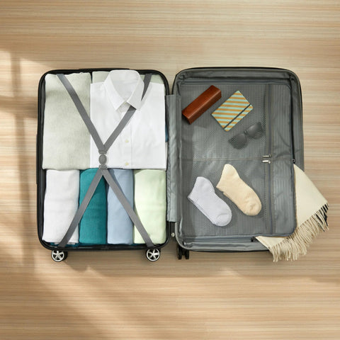 Top-down view of open Amazon Basics 30-inch black hardside spinner luggage, with clothes on left and mesh pocket on right.