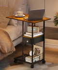 C-Shaped Side Table With Wheels And Large Wood Top beside bed, laptop and coffee on tabletop, drawer visible, metal frame.