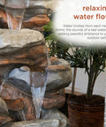 Close-up of 40-Inch Four Tier Rock Floor Fountain With Cascading Water And White LED Lights, indoor setting