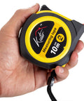 Hand holding 33 Ft Tape Measure With Magnetic Hooks And Fraction Markings Retractable Dual Sided Ruler Shock Absorbent Rubber Case