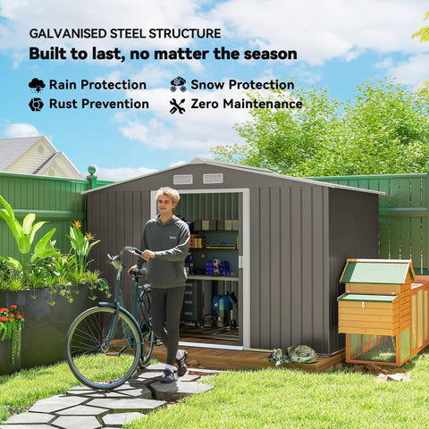 Person standing by 9x6 Outdoor Metal Storage Shed With Foundation Kit, Double Lockable Doors, Air Vents, Sloping Roof, for garden.