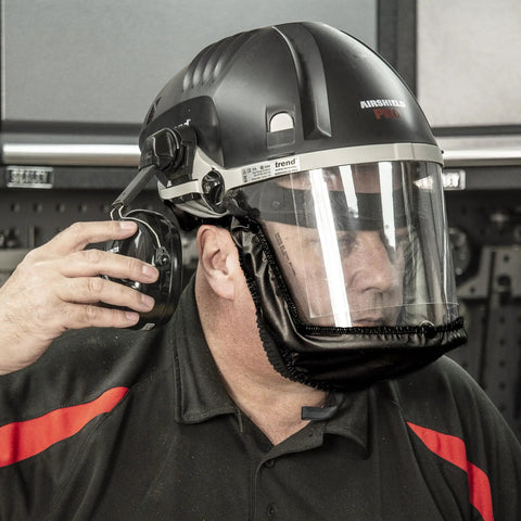 Close-up of man wearing Badass Powered Air Respirator And Hearing Protection Bundle For Woodworking Shops with ear protection.
