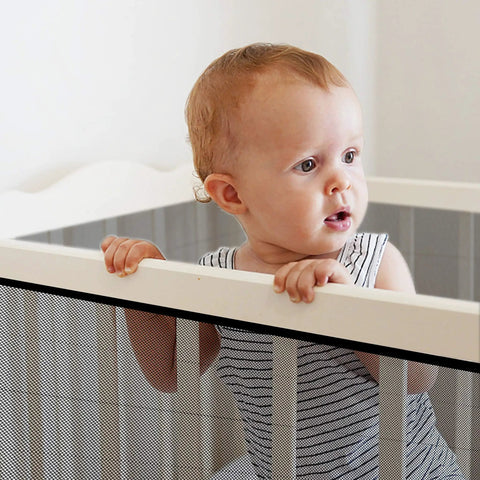 Child near stair banister with Stair Banister Guard Netting Kit For Kids And Pets 2 Pack 18 Ft By 2.6 Ft Mesh Safety Net installed.
