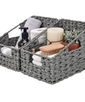 Two Pack Wicker Storage Baskets With Handles Odorless Waterproof Trapezoid Bins In Gray holding toiletries and a plant