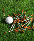 Western Birch Wood Golf Tees 100 Pack With Four Lengths scattered on grass next to a golf ball