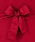Close-up of a red cotton duck canvas bow on a sofa slipcover with corner ties, 100% cotton, Duck Solid Box Cushion Sofa Slipcover One Piece.