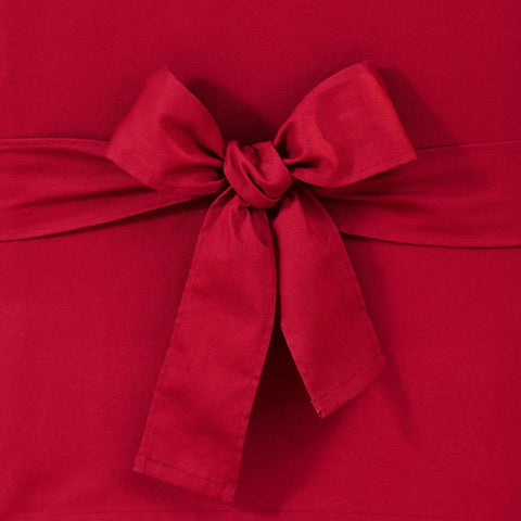 Close-up of a red cotton duck canvas bow on a sofa slipcover with corner ties, 100% cotton, Duck Solid Box Cushion Sofa Slipcover One Piece.
