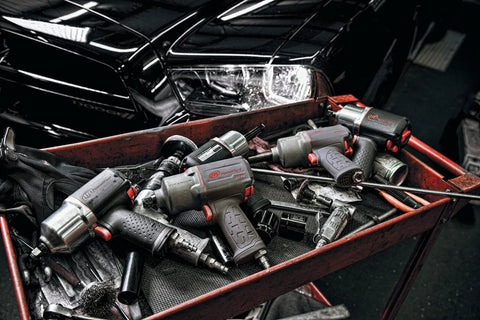 Heavy Duty Half Inch Drive Pneumatic Air Impact Wrench Delivers Over 1100 Ft Lbs Of Bone Crushing Torque on a workshop cart with tools.