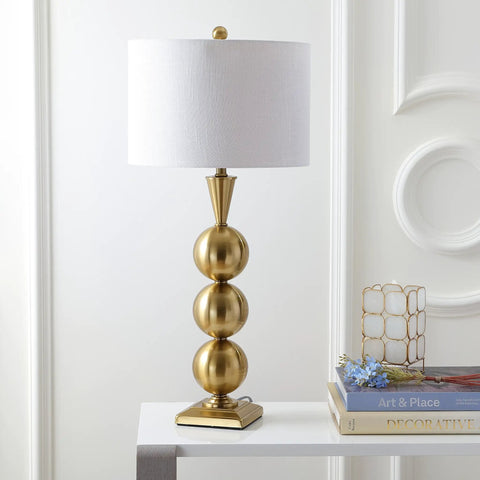 Brass Gold Stacked Orb LED Table Lamp 33 Inch Tall With White Linen Drum Shade Dope Modern Transitional Bedside Or Living Room Light LED Bulb Included Energy Saving ETL Listed For Safety on a table next to books