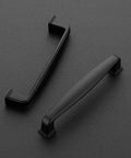 Two matte black handles from 25 Pack Solid 3-3/4 Inch Matte Black Kitchen Cabinet Handles Set With 4-1/4 Inch Overall Length, 1/2 Inch Width, And 29/32 Inch Projection, Durable Drawer Pulls For Cabinets, Cupboards And Doors on gray background