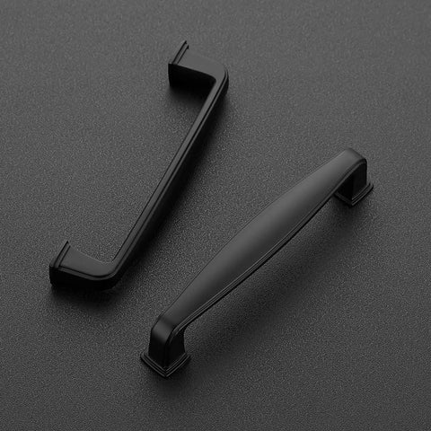 Two matte black handles from 25 Pack Solid 3-3/4 Inch Matte Black Kitchen Cabinet Handles Set With 4-1/4 Inch Overall Length, 1/2 Inch Width, And 29/32 Inch Projection, Durable Drawer Pulls For Cabinets, Cupboards And Doors on gray background
