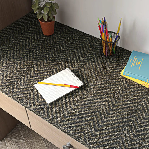 Geometric Grasscloth Black And Gold Peel And Stick Wallpaper Dope Self Adhesive Vinyl Removable on desk surface with books and plant