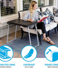 Woman using Stacking Compact Folding Table 30 By 20 Inches For Indoor And Outdoor Use Portable Black And Silver Folding Table on patio.