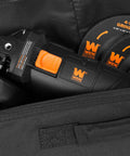 Close-up of black and orange Seven Point Five Amp Four And A Half Inch Angle Grinder With Reversible Handle in carrying case.
