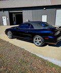 Top Shelf Tinted Blue Paint Basecoat Gallon Ready To Spray With Slow Reducer Blend For Ultra Smooth Automotive Finish That Hits Perfect And Looks Totally Fresh On Any Ride parked near a building.