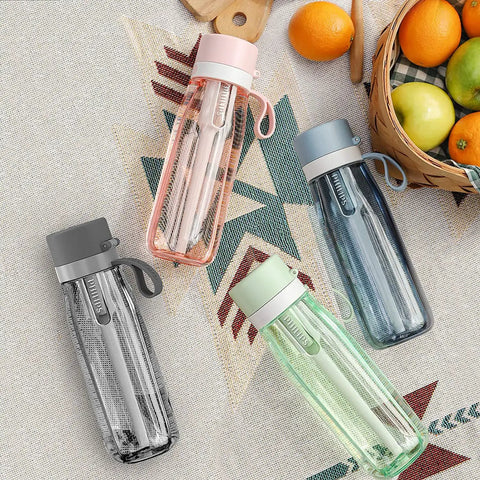 Four GoZero Everyday Water Filter Bottle 22 Oz BPA Free Tritan Plastic Reusable Bottles on a table with fruit and a basket.