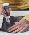 Person applying Seam Grip TF Tent Fabric Sealer For Waterproofing And Restoring PU Coatings On Nylon Tent Floors, Rainflies, And Tarps