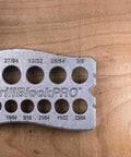 All Metal Handheld Drill Guide for Straight Holes with marked drill sizes on a wooden surface