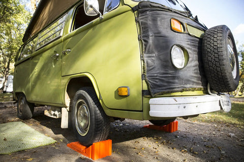 Stop N Chock 2 Pack For No Fuss Safe Parking And Easy Stabilization Interlocks With Levelers Durable Porous PLA Construction Delivers Strong Grip And Quick Setup in use with green RV on gravel