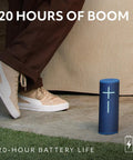 Megaboom 4 Portable Waterproof Bluetooth Speaker with 360° sound, 20-hour battery, shown outdoors next to person's foot.