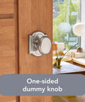 One-sided dummy knob in satin nickel on wooden door, living room in background